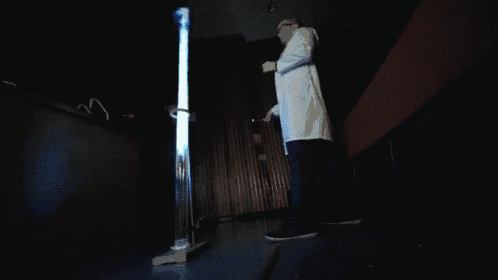 a man in a lab coat is standing in front of a glowing object
