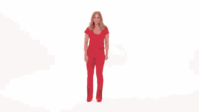 a woman in red pants and a red shirt is dancing on a white background