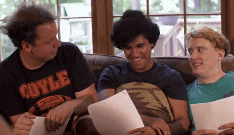a man wearing a coyle shirt sits with two other men