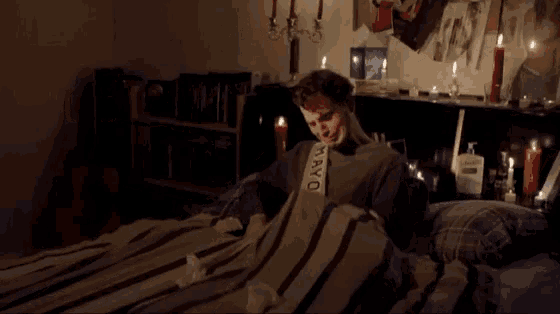 a man wearing a mayor sash is laying on a bed