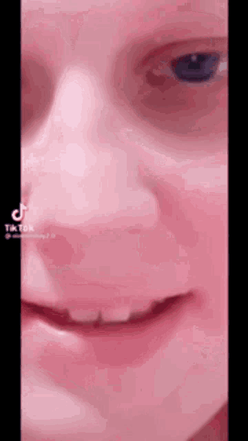 a close up of a person 's face with a blue eye