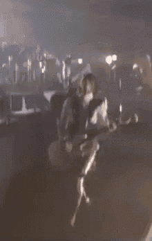 a person is playing a guitar on a stage .