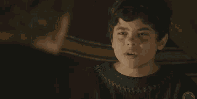 a young boy in a black sweater is talking to a man