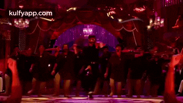 a man is dancing in front of a crowd of people in a club .