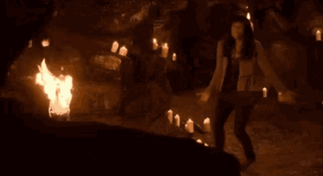 a group of people are sitting around a table with candles .