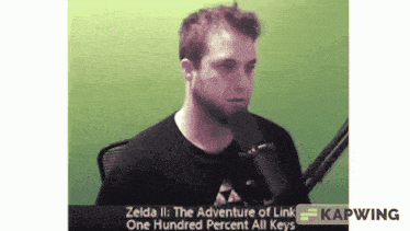 a man speaking into a microphone with the words zelda ii the adventure of link one hundred percent all keys