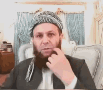 a man with a beard is sitting in a chair