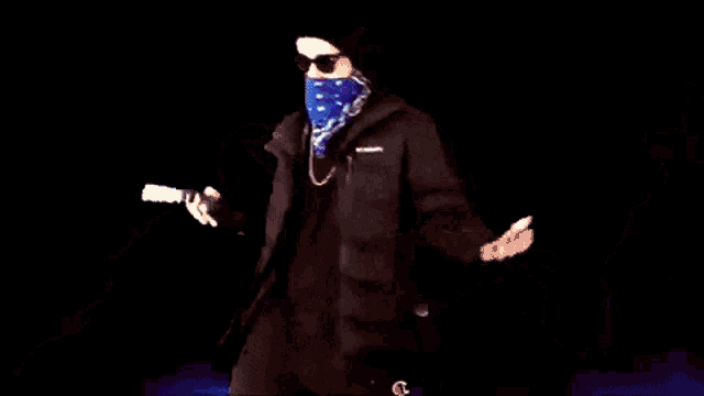 a man wearing sunglasses and a blue bandana holds a gun