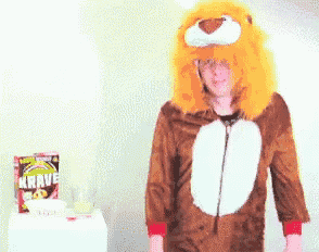 a man in a lion costume is standing in front of a box of krave