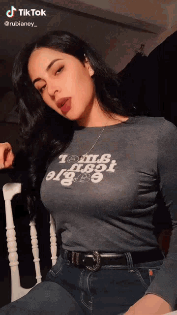a woman wearing a t-shirt that says " tom & jerry " is sitting in a chair