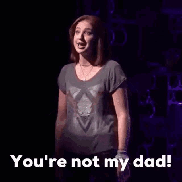 a woman is singing on a stage and saying you 're not my dad .