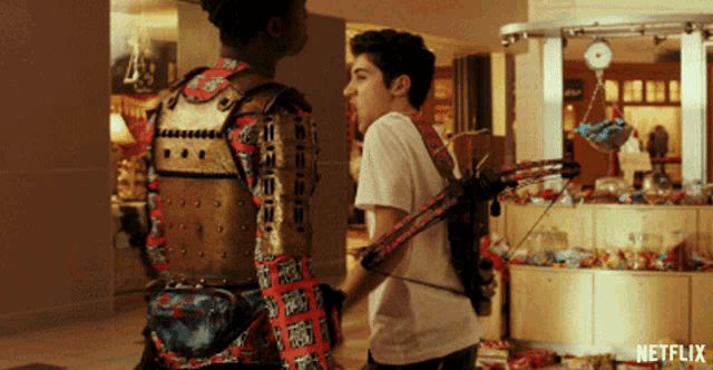 a man with a bow and arrow is standing next to another man with a samurai costume