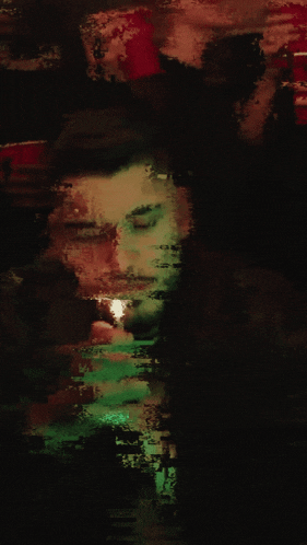 a blurry picture of a man lighting a cigarette in a dark room