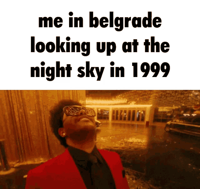 a man in a red suit looks up at the night sky