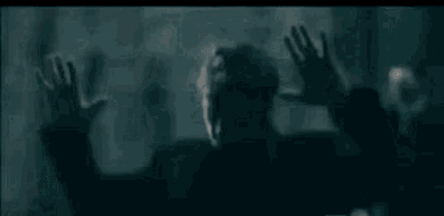 a man in a black jacket is dancing in a dark room .