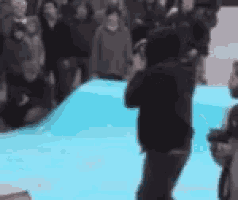 a blurry picture of a man standing on a blue surface