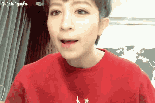 a close up of a person wearing a red shirt with the name quinh nguyen written on it