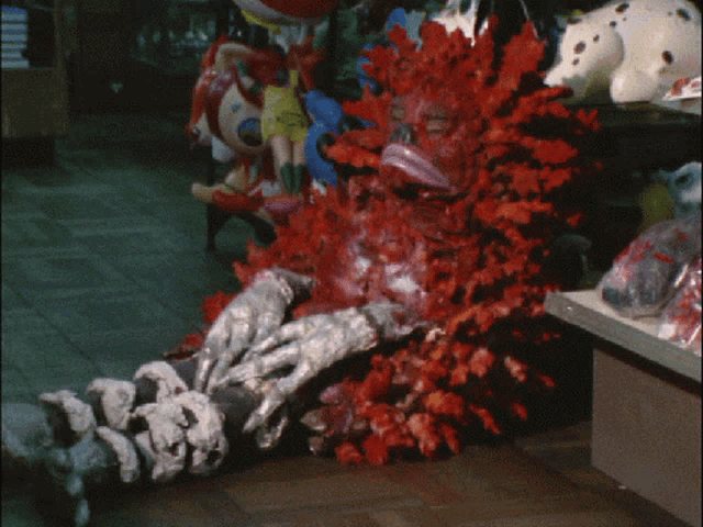 a statue of a monster is surrounded by balloons