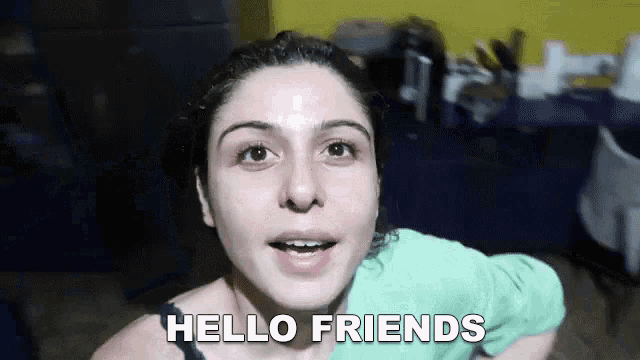 a woman is saying hello friends in a dark room
