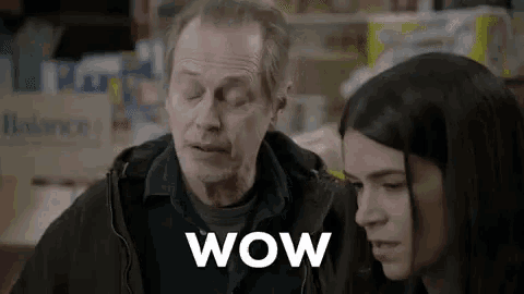 a man and a woman are standing next to each other in a store . the man is saying wow .