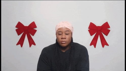 a man with a bandage on his head is standing in front of two red bows