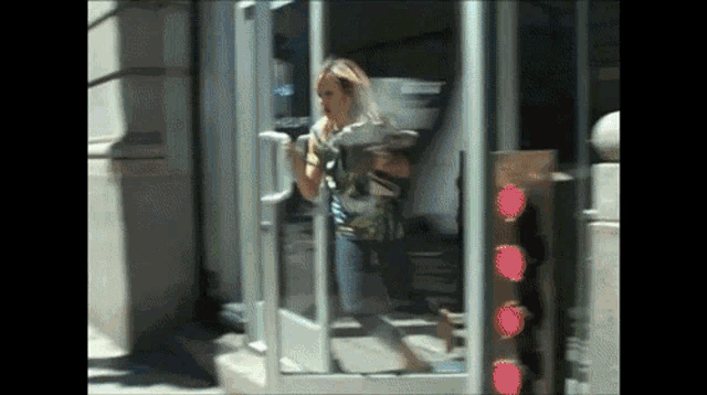a woman standing in a doorway with a red light in the background