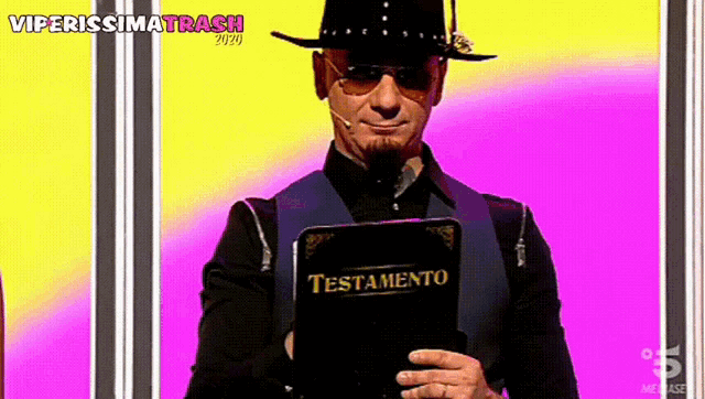 a man holding a book that says testamento