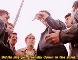 a group of men are standing in a circle with the words while she got friendly down in the sand below them
