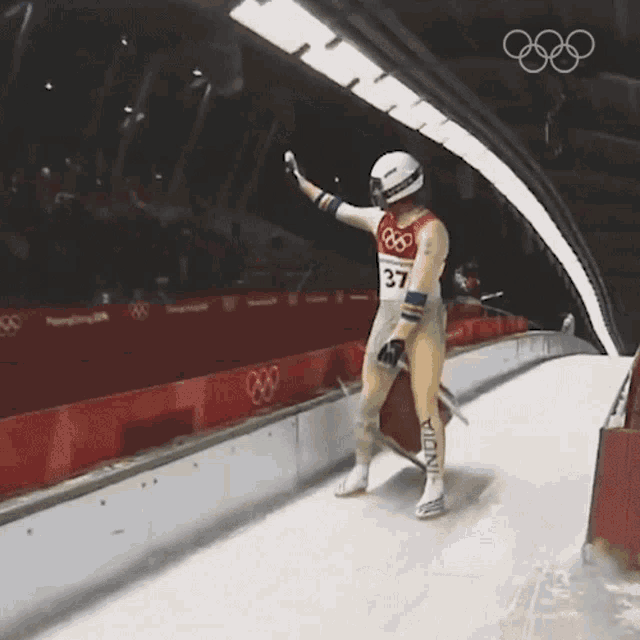 a man wearing a number 37 jersey stands on a snowy track