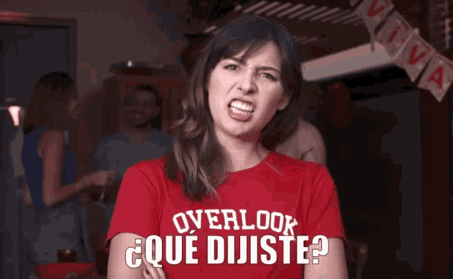 a woman wearing a red t-shirt that says overlook que dijiiste