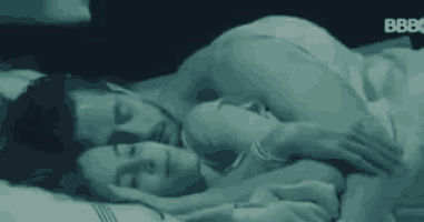 a man and a woman are sleeping together in a bed .
