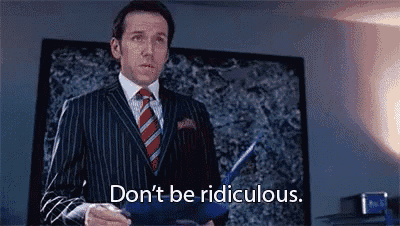 a man in a suit and tie is holding a piece of paper and saying `` don 't be ridiculous '' .