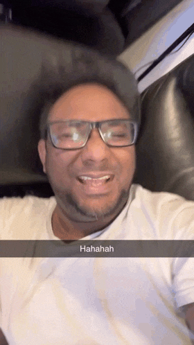a man wearing glasses and a white shirt is laughing with a caption that says ' hahahaha '