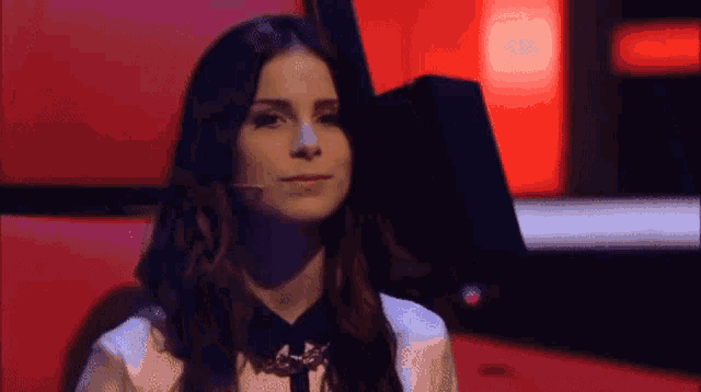a woman sitting in a chair with a microphone in her hand