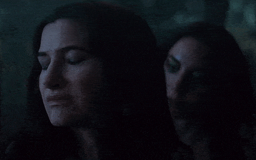a woman with her eyes closed is standing next to another woman with her eyes closed