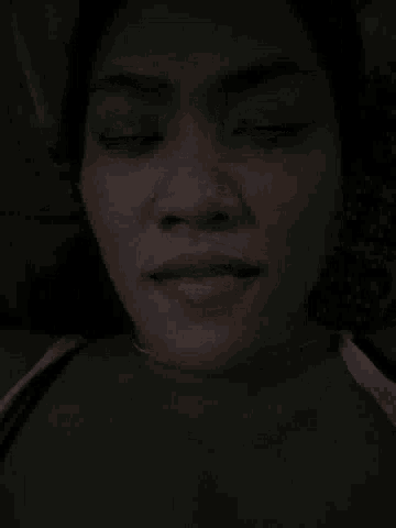a woman with her eyes closed and her tongue out