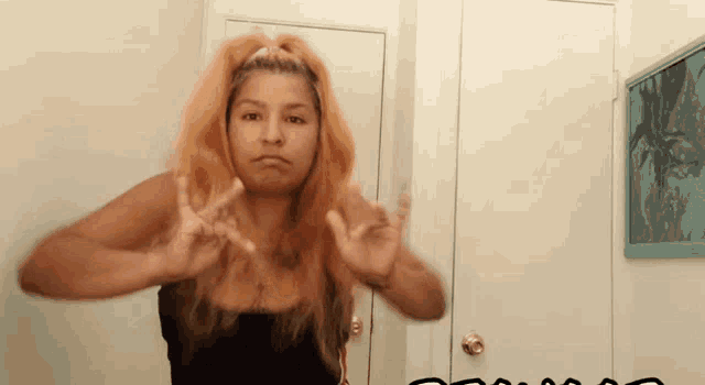 a woman is making a peace sign with her hands
