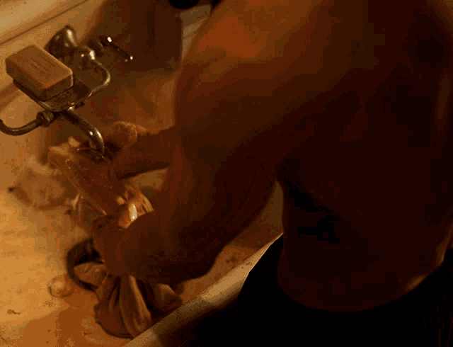 a man washing his hands in a sink with a soap bar on the faucet