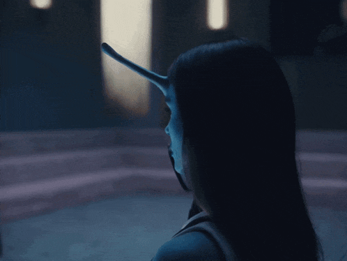 a woman with horns on her head is looking down