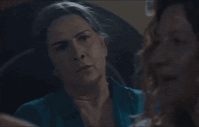 a close up of a woman 's face in a dark room