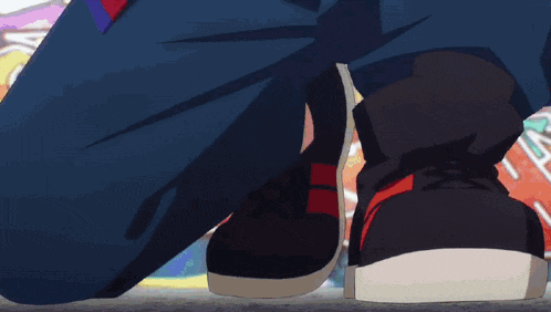 a person wearing a pair of black sneakers with red stripes