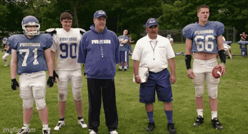 a group of football players are standing on a field and one has the number 66 on his shirt