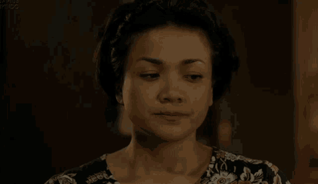a close up of a woman 's face with a floral top