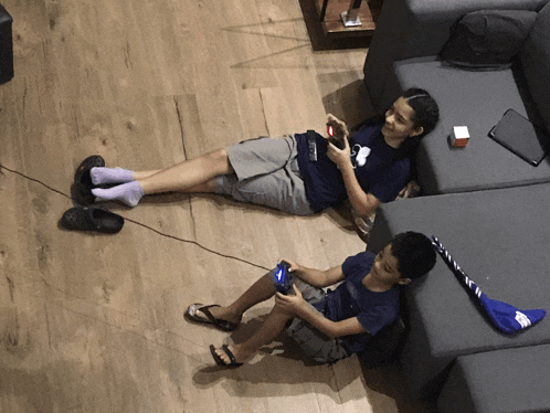 a girl laying on the floor playing a video game