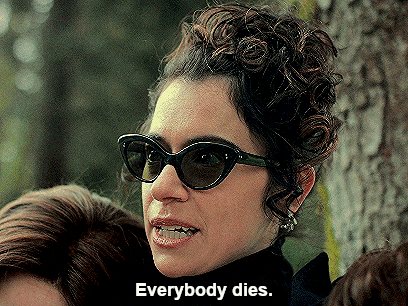 a woman wearing sunglasses says " everybody dies " in front of a tree