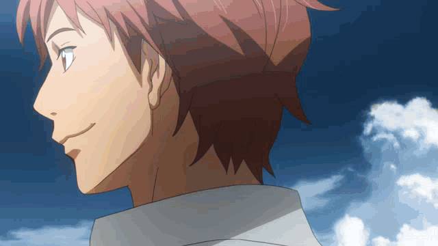 a man with red hair is smiling in front of a blue sky with clouds