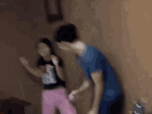 a boy and a girl are dancing in a living room while holding wii remotes .