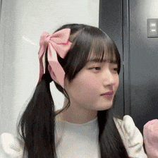 a girl with pigtails and a pink bow on her hair