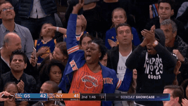 a woman in a new york knicks jacket stands in a crowd