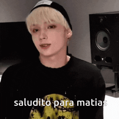 a young man with blonde hair is wearing a black shirt and a black beanie .